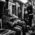 Couple de jeunes regardant un téléphone en souriant dans une rame de métro